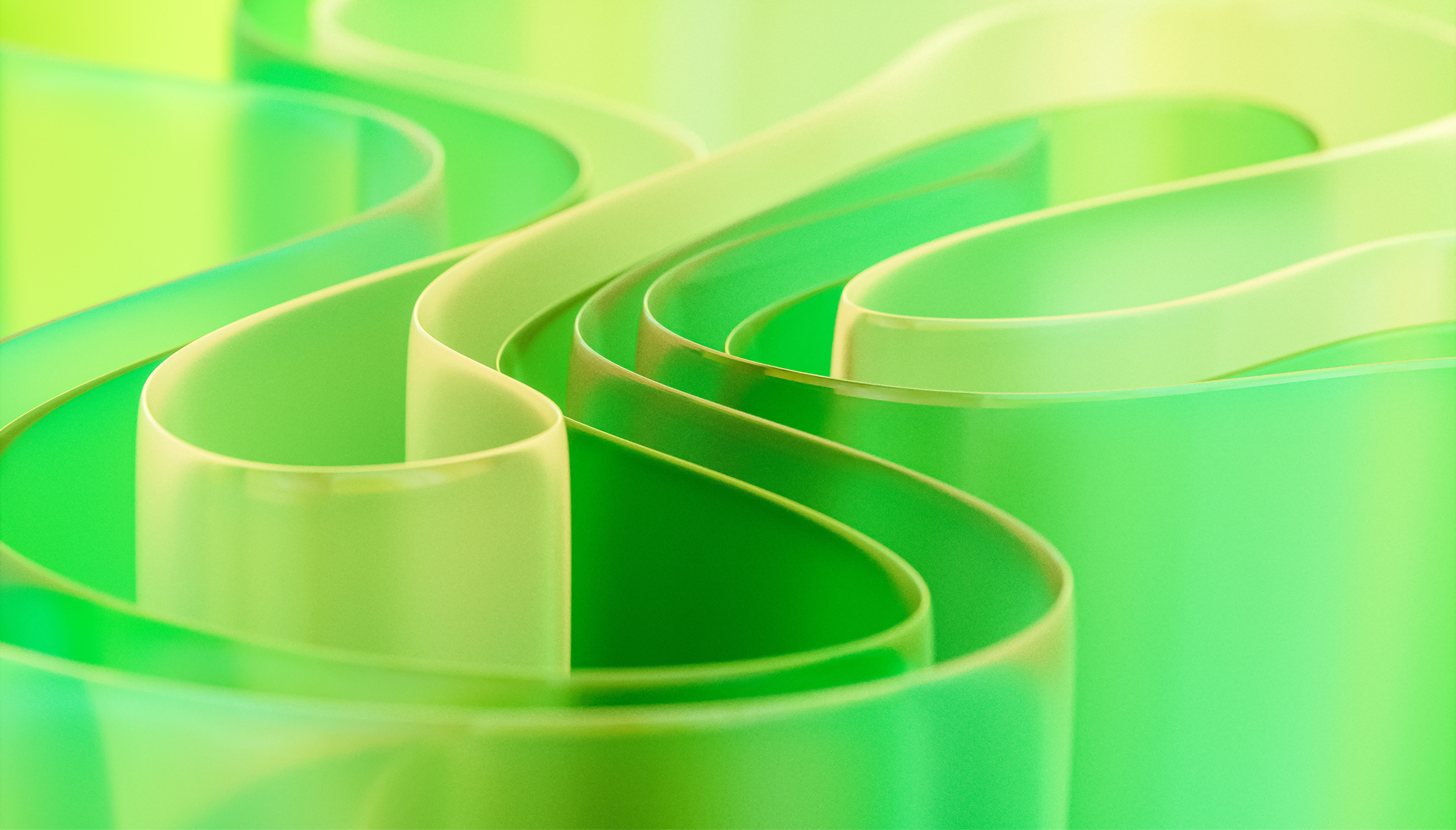 Abstract green translucent ribbons flowing in S-curves with a glossy glass-like finish and bokeh.