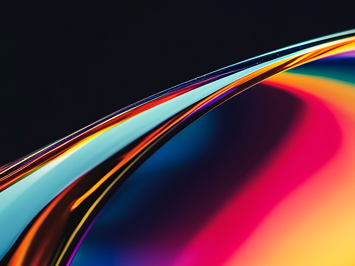 Abstract digital art with vibrant blue, magenta, pink and orange gradients flowing along a luminous curve.