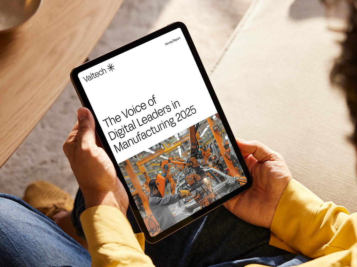 Person viewing Valtech survey report, The Voice of Digital Leaders in Manufacturing 2025, on tablet.
